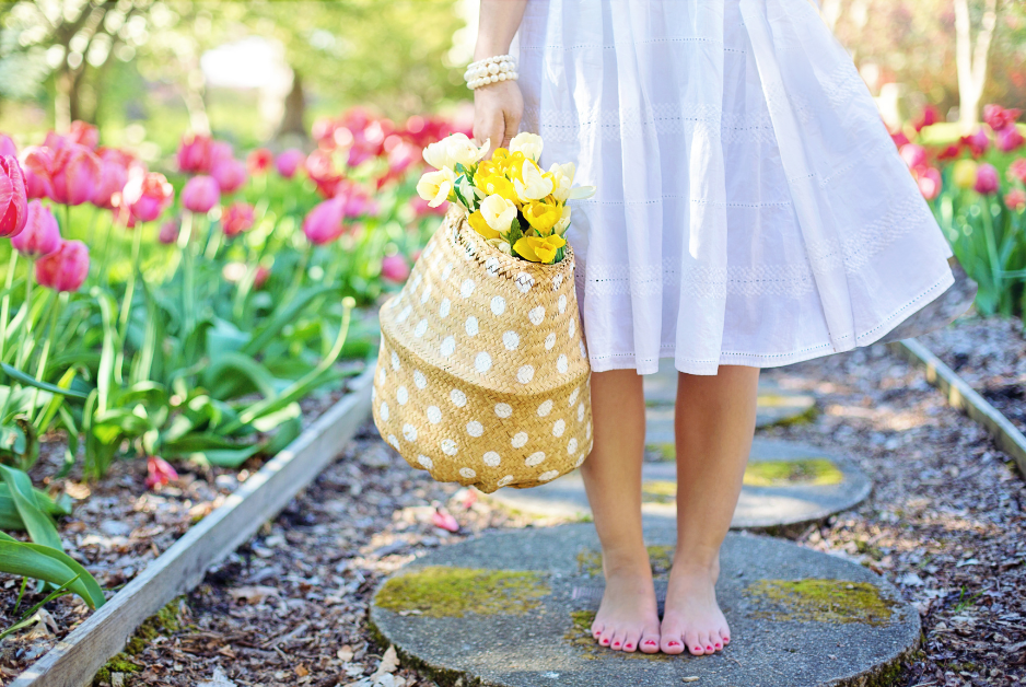 Walking down garden path with basket of flowers